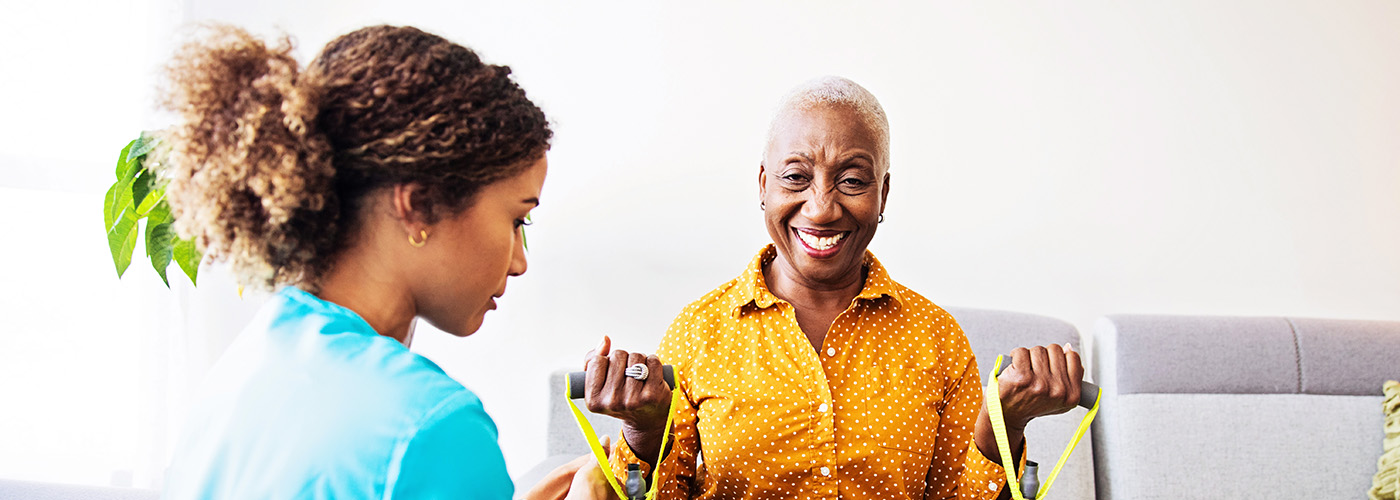 Elderly woman exercises with guidance, smiling happily.